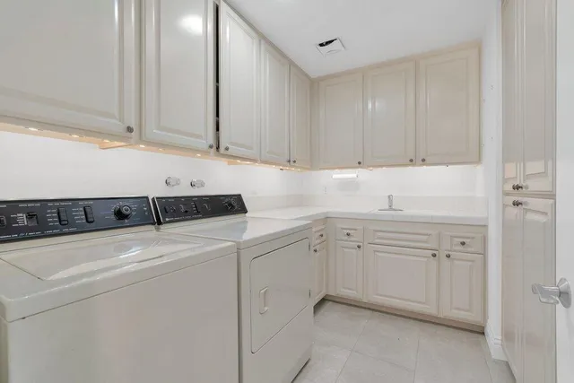 a spacious bathroom with a double vanity sink large mirror and a bathtub