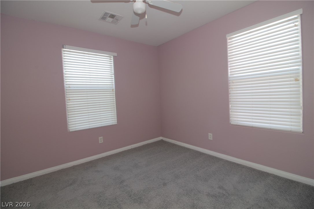9289 Valley Ranch Avenue Las Vegas, NV 89178 - Photo 27 of 29 A well-lit bedroom with comfortable carpeting, perfect for relaxation.