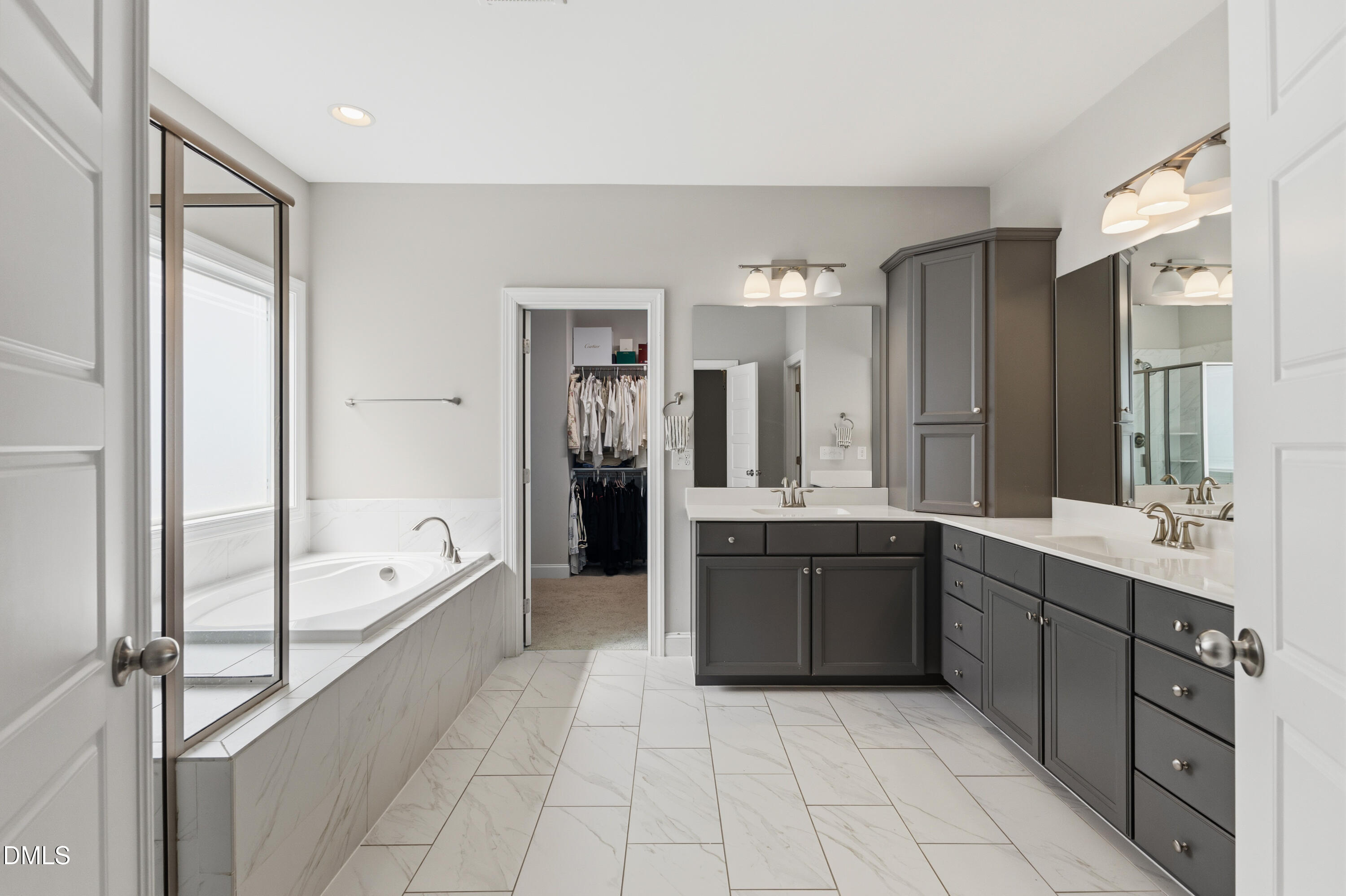 7421 Stonehenge Farm Lane Raleigh, NC 27613 - Photo 12 of 48 a large bathroom with a double vanity sink a large mirror and a bathtub