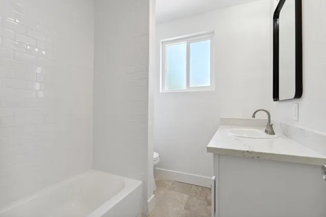 an empty room with wooden floor cabinet and windows