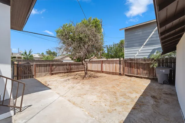 a white house with a large tree in front of it