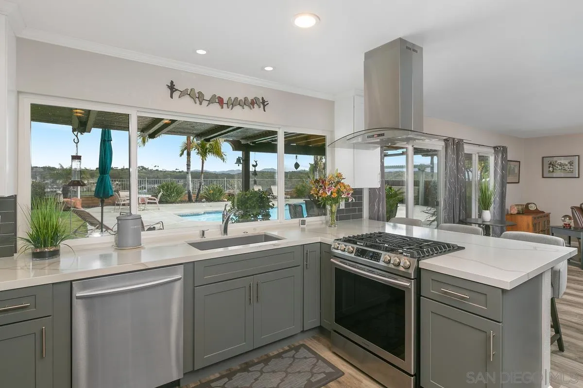 10934 Avenida Roberta Spring Valley, CA 91978 - Photo 11 of 30 a kitchen with stainless steel appliances granite countertop a sink and a stove