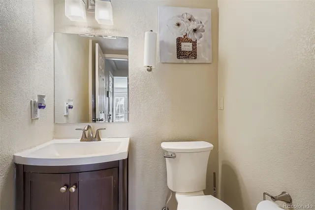 a bathroom with a toilet sink and mirror