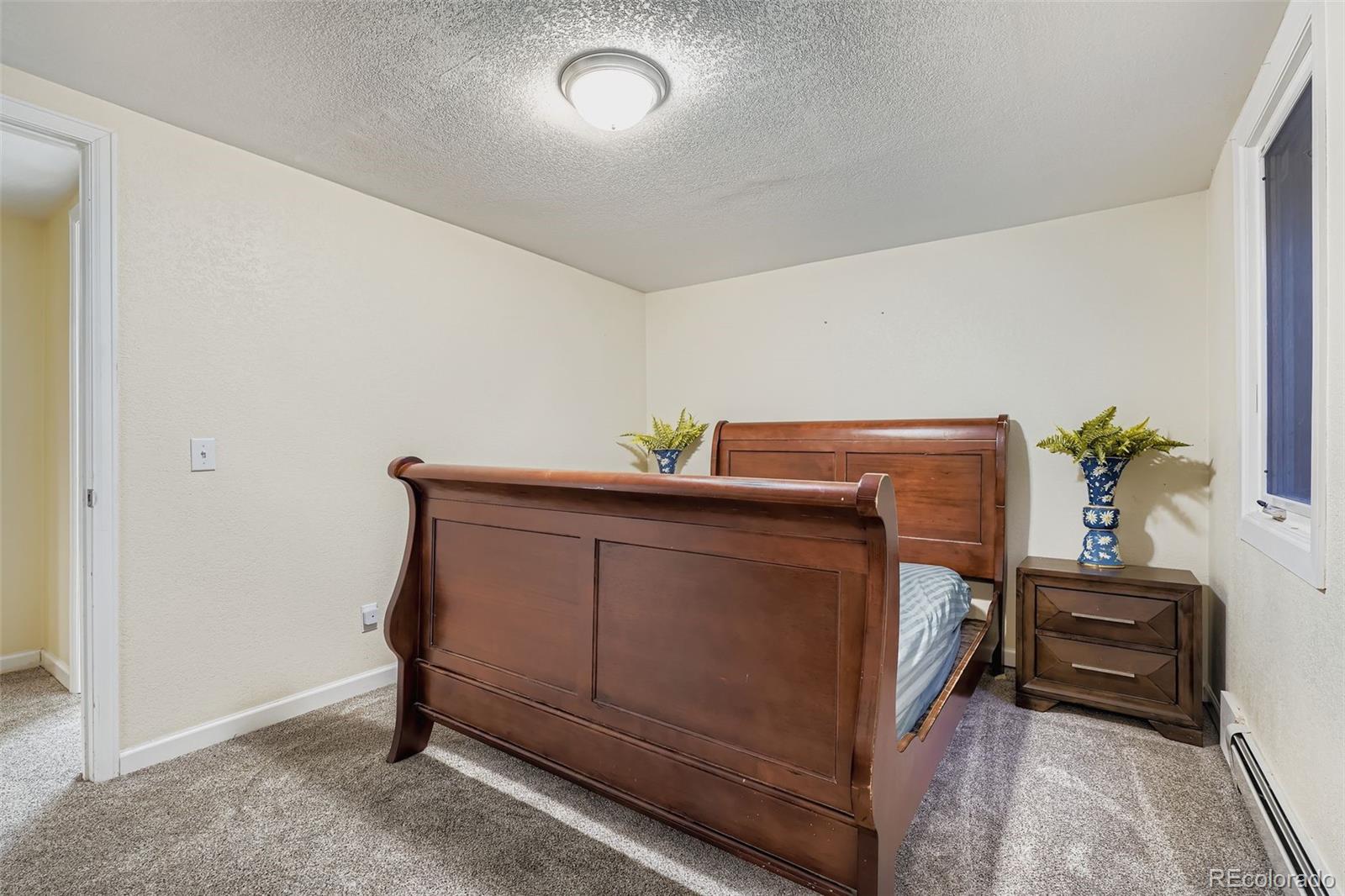 3301 South Magnolia Street Denver, CO 80224 - Photo 24 of 33 a bedroom with a bed and a potted plant