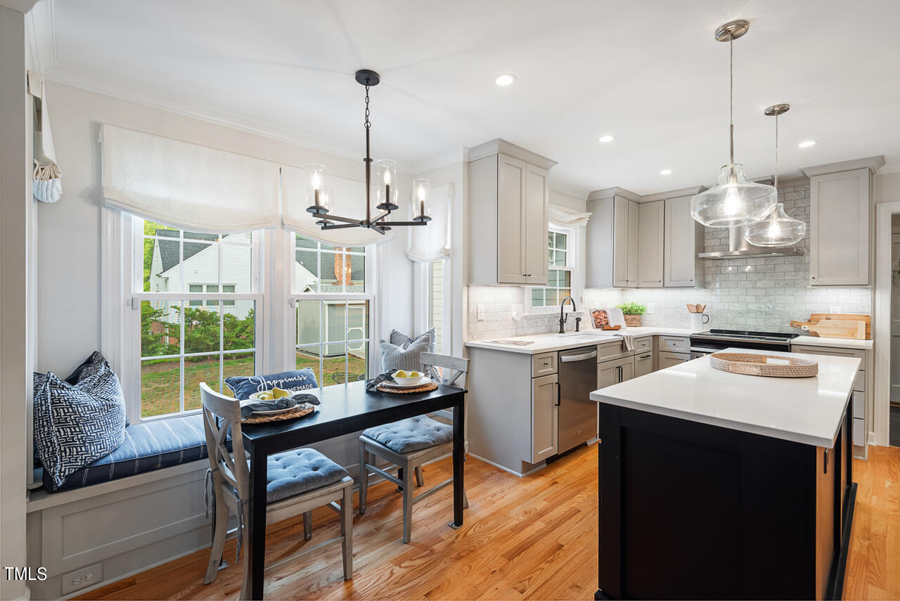 5 Caspian Court Durham, NC 27713 - Photo 11 of 48 a kitchen with a sink a stove a dining table and chairs