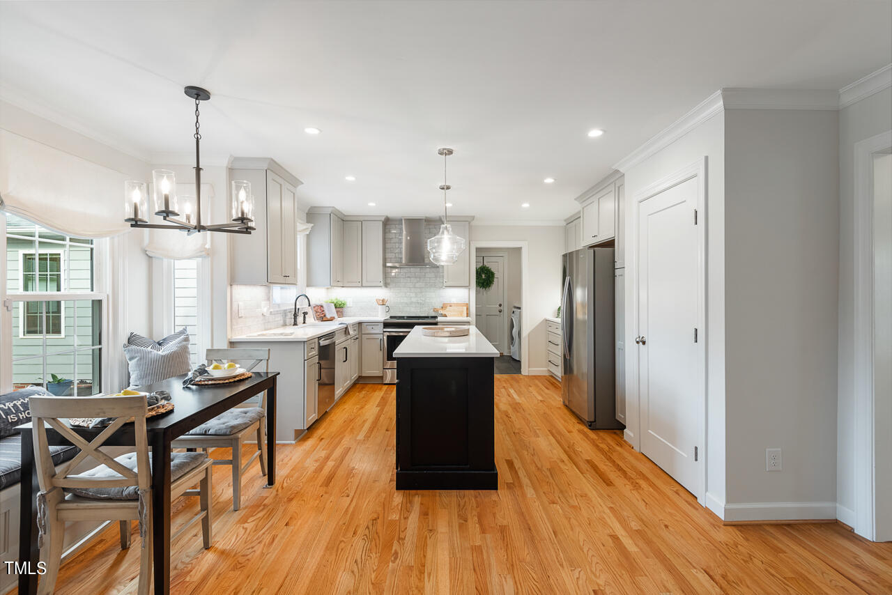 5 Caspian Court Durham, NC 27713 - Photo 13 of 48 a kitchen with a table chairs refrigerator and wooden floor