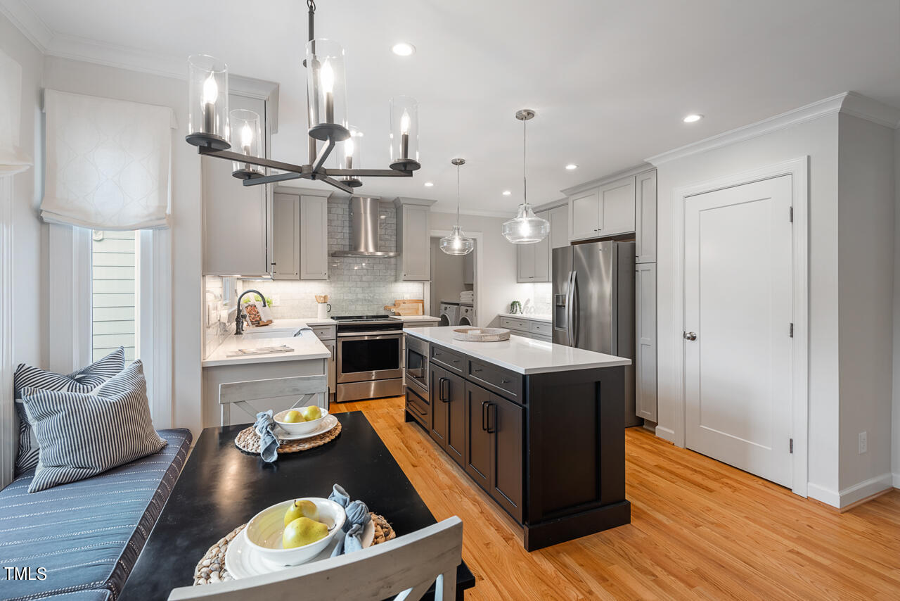 5 Caspian Court Durham, NC 27713 - Photo 14 of 48 a kitchen with kitchen island a stove a refrigerator and a wooden floor