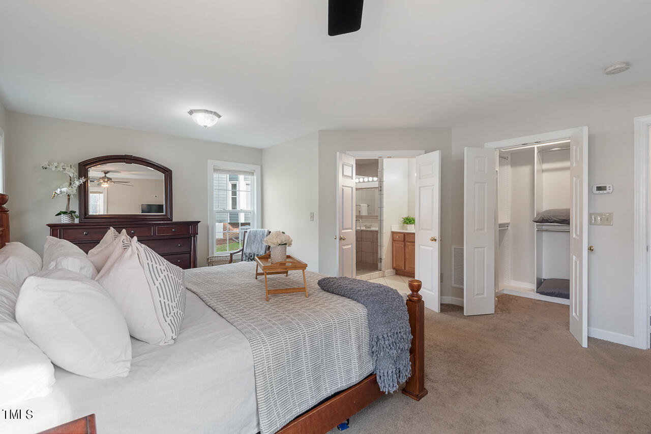 5 Caspian Court Durham, NC 27713 - Photo 22 of 48 a bedroom with a bed a mirror and a dresser with projector