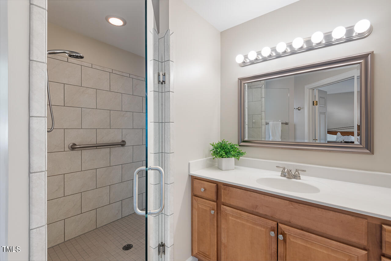 5 Caspian Court Durham, NC 27713 - Photo 23 of 48 a bathroom with a granite countertop sink a mirror and a shower