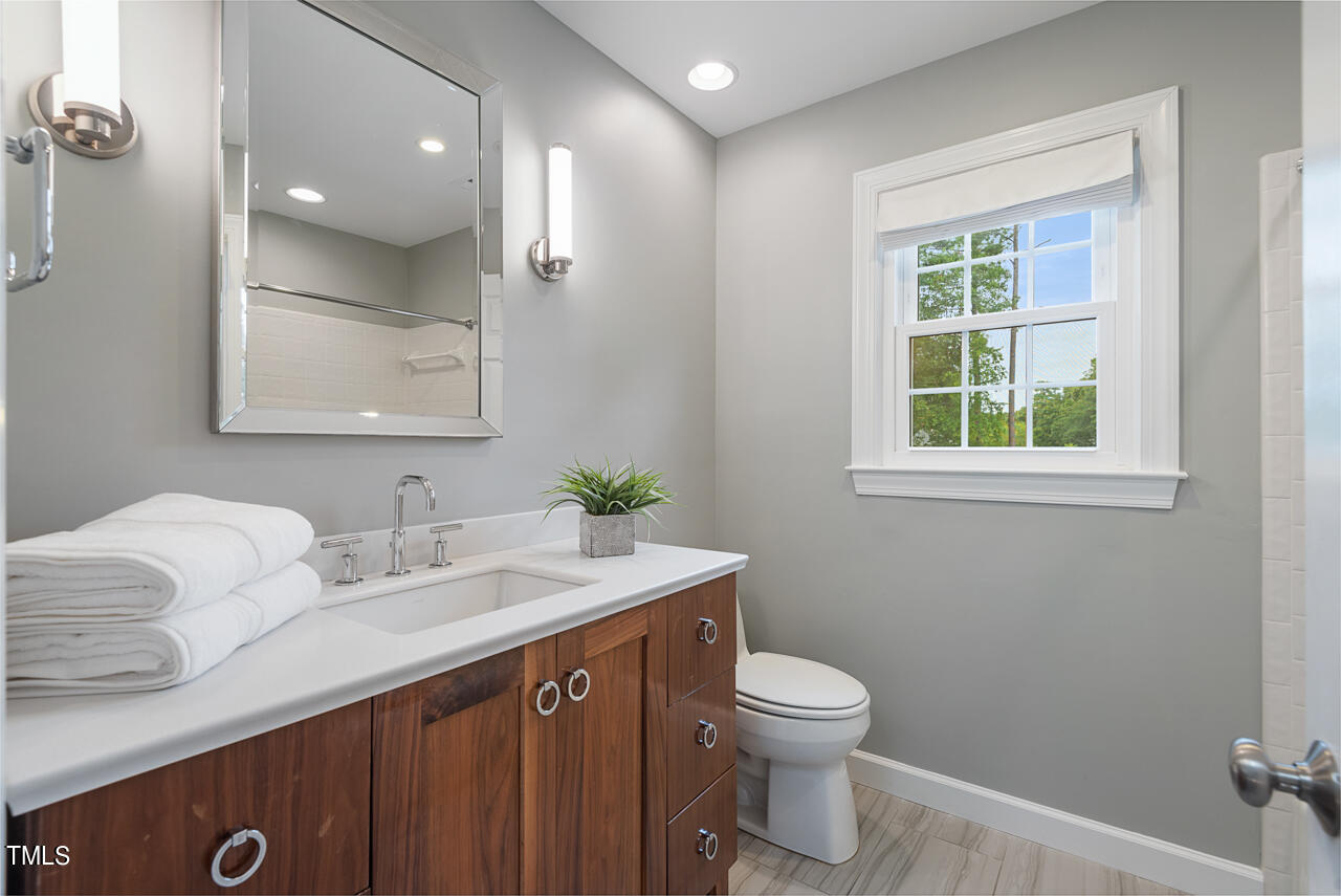 5 Caspian Court Durham, NC 27713 - Photo 36 of 48 a bathroom with a granite countertop sink toilet and mirror