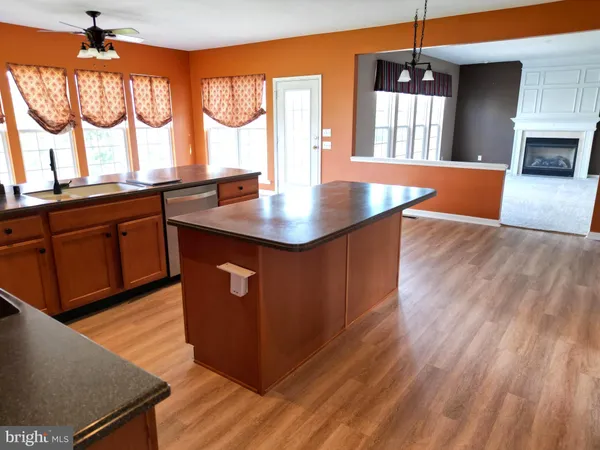 a kitchen with stainless steel appliances granite countertop a sink a window and wooden floor