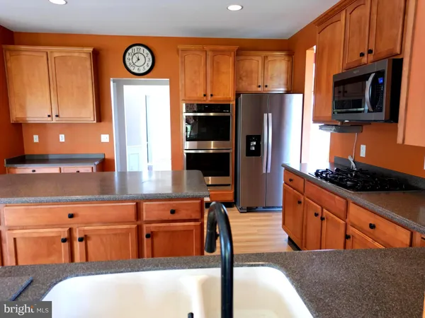 a kitchen with stainless steel appliances granite countertop a refrigerator stove top oven a sink and dishwasher