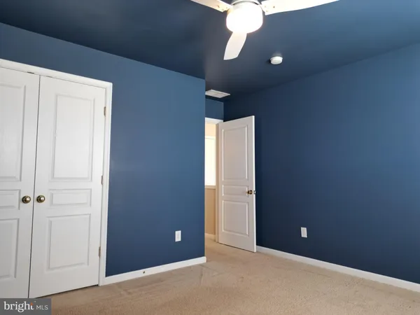 a view of an empty room with a chandelier fan