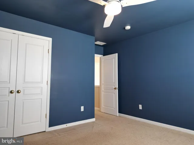 a view of an empty room with a chandelier fan