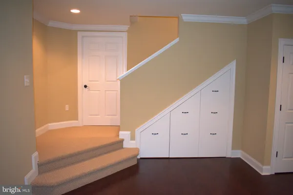 a view of hallway with stairs and wooden floor