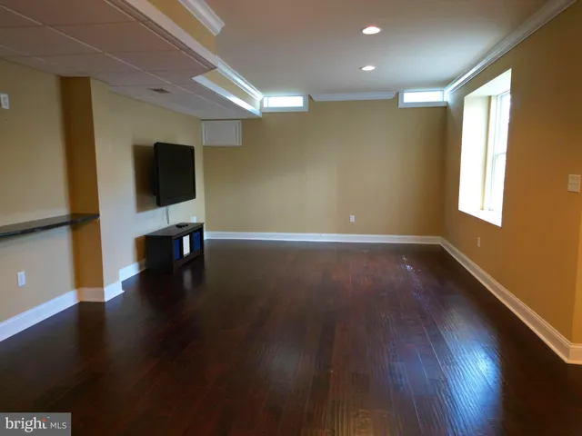 a view of a livingroom with wooden floor and a flat screen tv