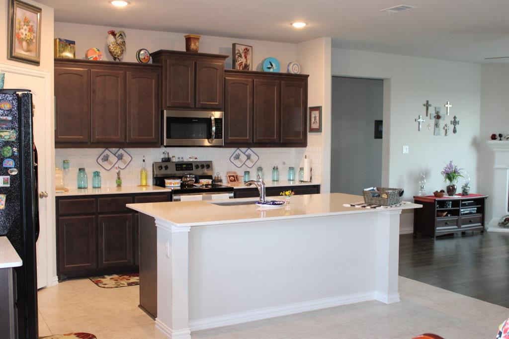 2267 County Road 4010 Decatur, TX 76234 - Photo 11 of 36 a kitchen with stainless steel appliances a stove top oven a sink and a refrigerator