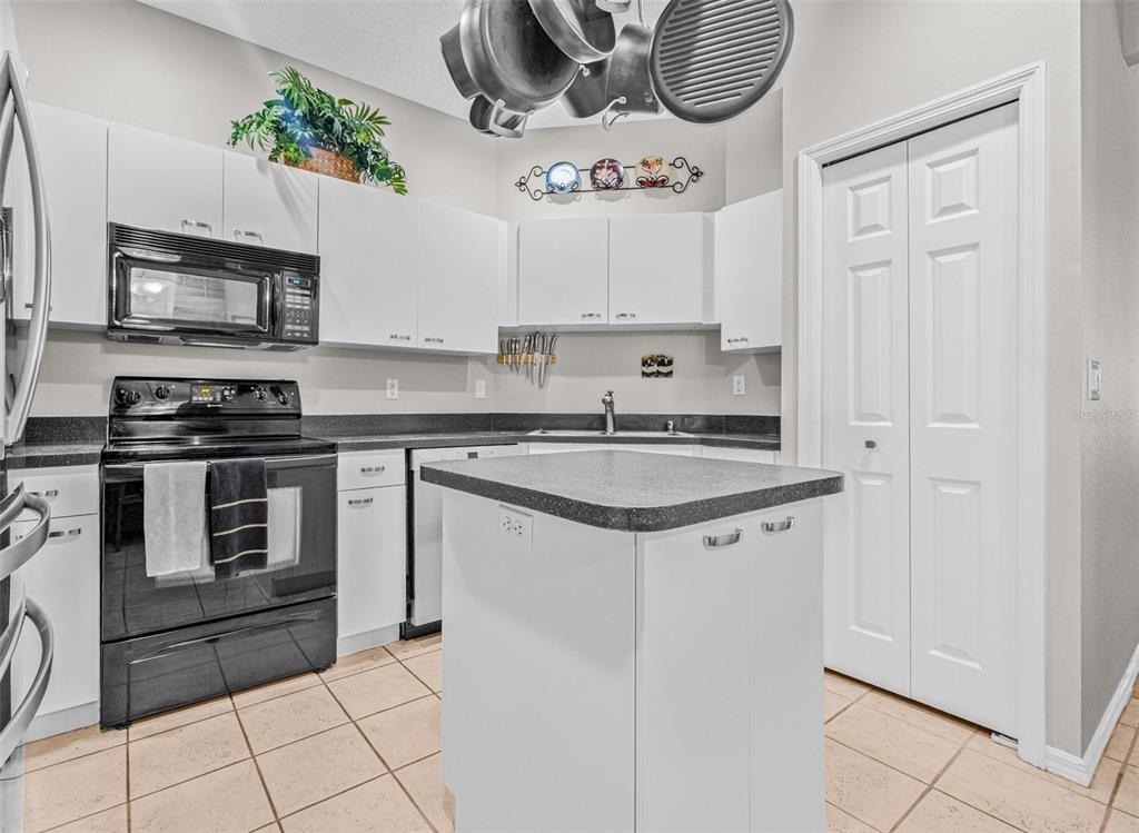 1050 Starkey Road, Unit 604 Largo, FL 33771 - Photo 10 of 28 a kitchen with stainless steel appliances granite countertop a stove a sink and a refrigerator