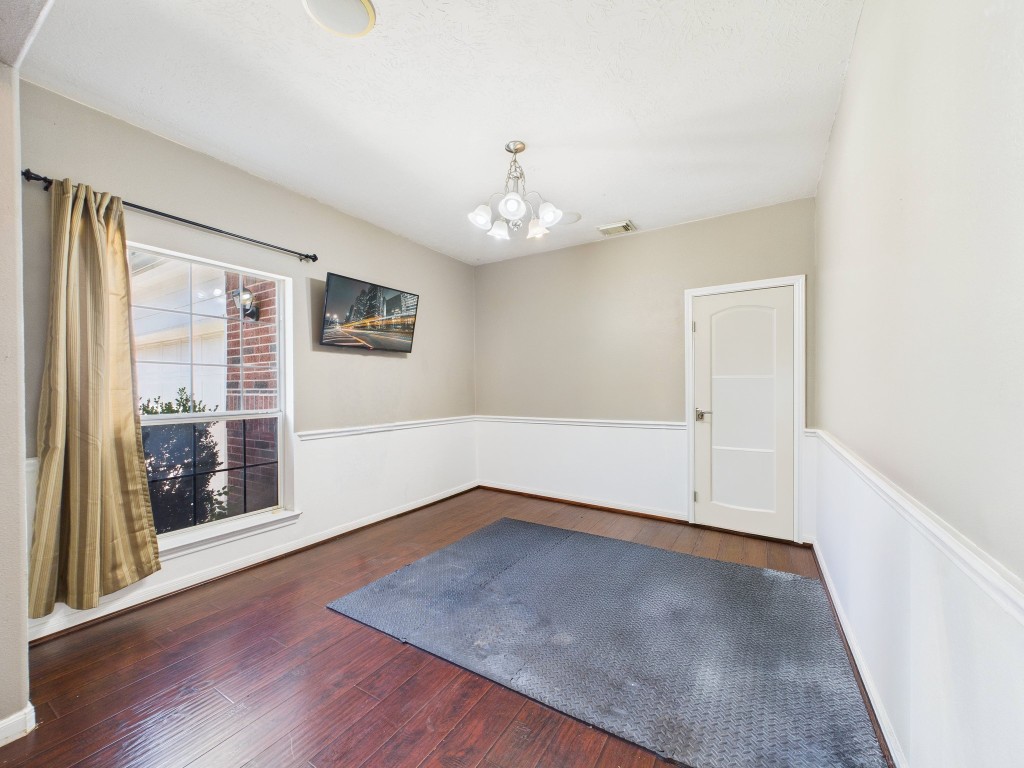 1484 Allison Street Alvin, TX 77511 - Photo 5 of 37 an empty room with wooden floor chandelier and windows