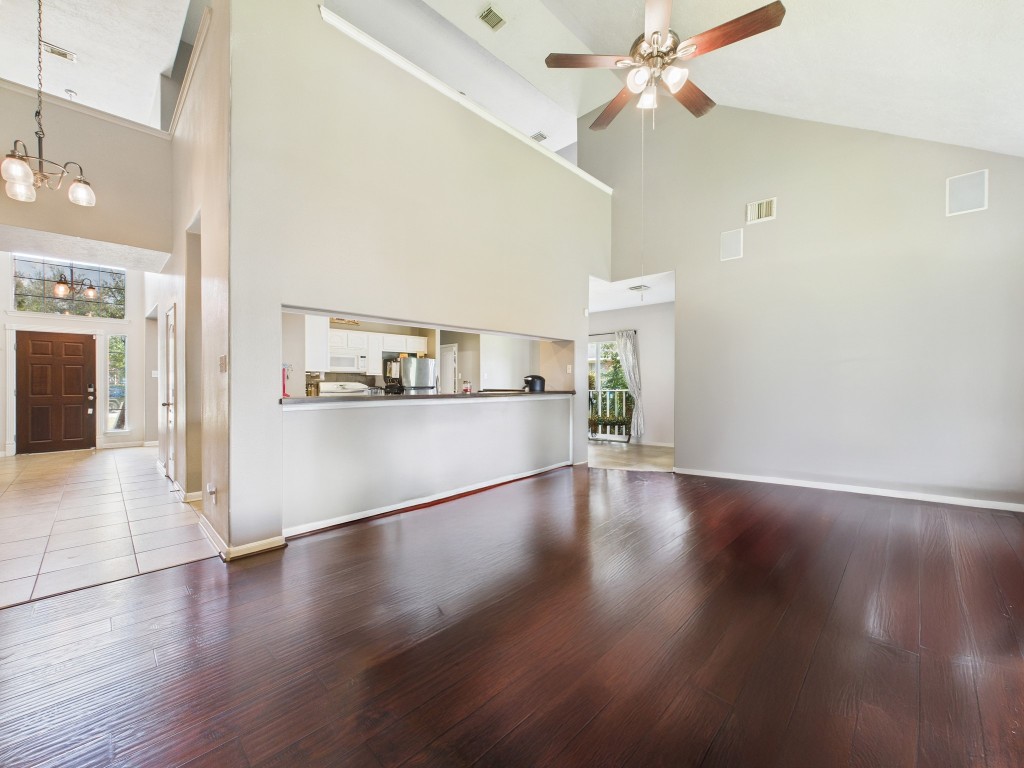1484 Allison Street Alvin, TX 77511 - Photo 9 of 37 a view of a kitchen and an empty room with wooden floor