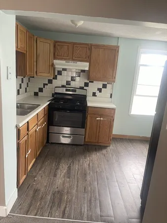 a kitchen with kitchen island granite countertop wooden cabinets and white appliances