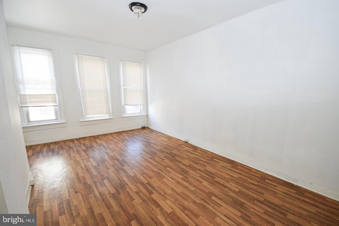 2101 West Baltimore Street Baltimore, MD 21223 - Photo 11 of 19 an empty room with wooden floor and windows