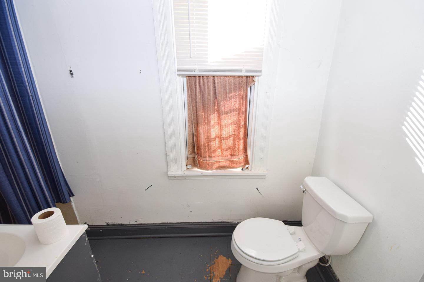 2101 West Baltimore Street Baltimore, MD 21223 - Photo 14 of 19 a bathroom with a toilet a sink and a window