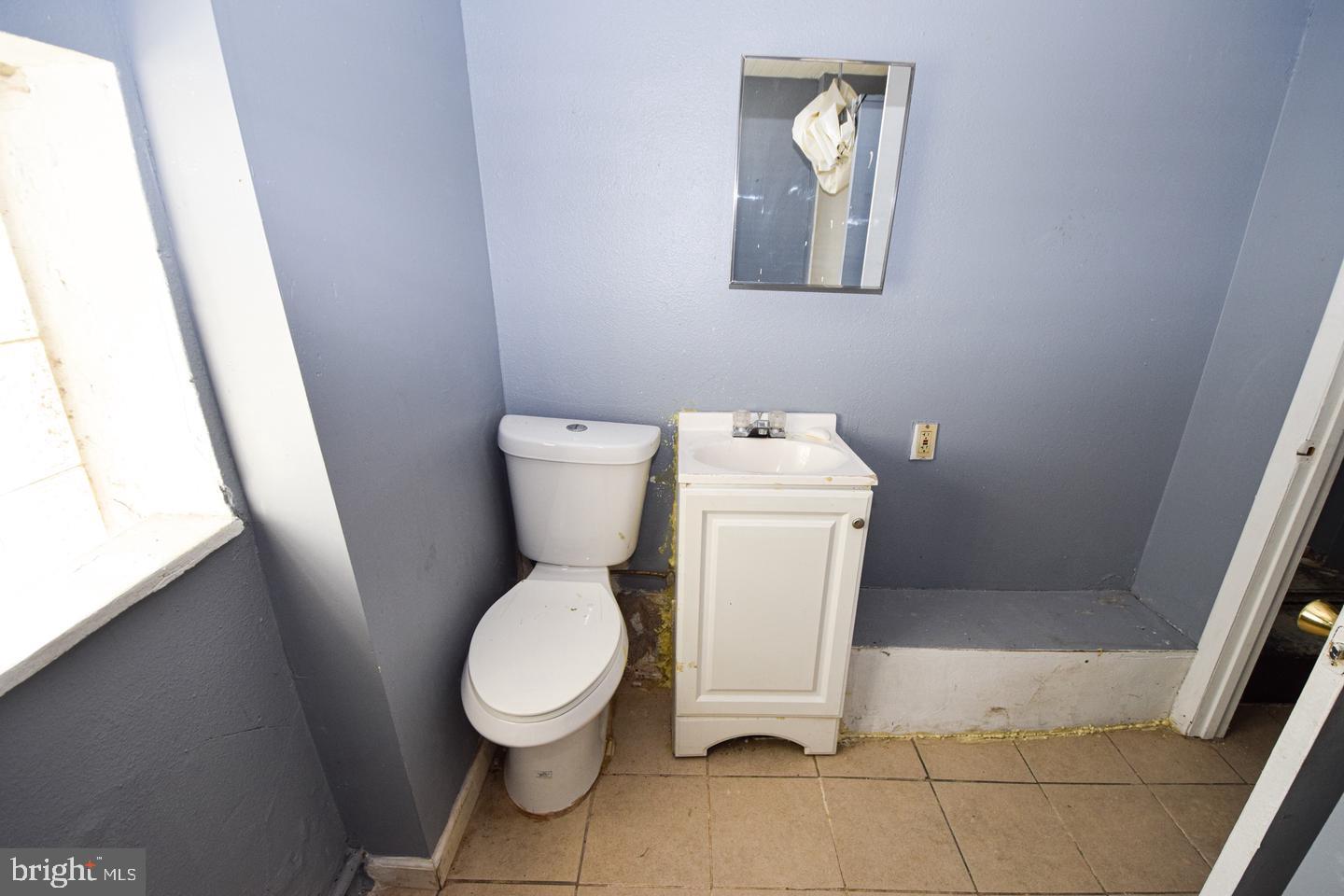 2101 West Baltimore Street Baltimore, MD 21223 - Photo 17 of 19 a white toilet sitting next to a small sink