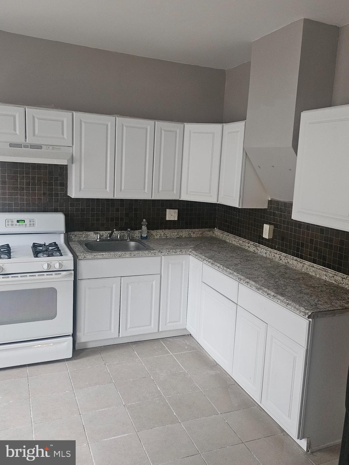 2101 West Baltimore Street Baltimore, MD 21223 - Photo 8 of 19 a kitchen with granite countertop a sink a stove and cabinets