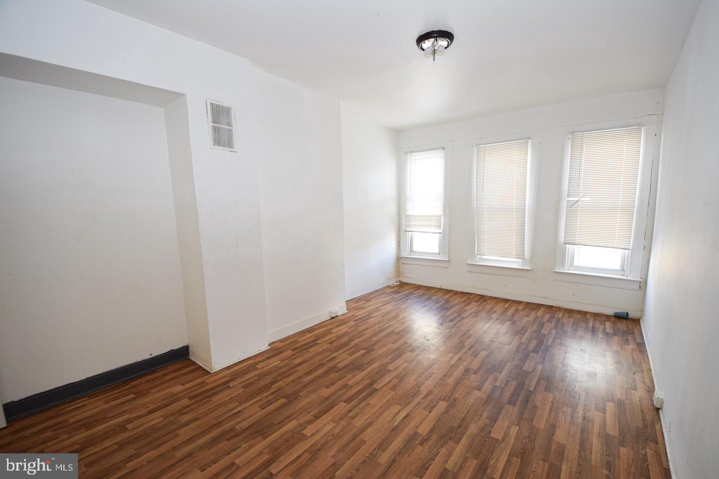 2101 West Baltimore Street Baltimore, MD 21223 - Photo 9 of 19 a view of an empty room with wooden floor and a window