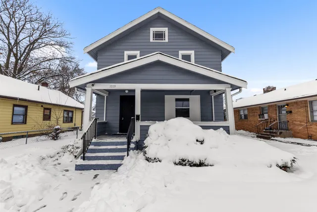 a view of a house with wooden roof and a large tree