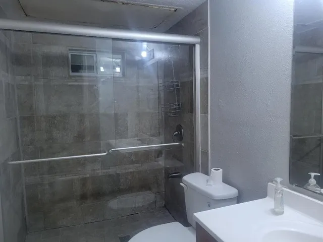 an empty room with a ceiling fan and window