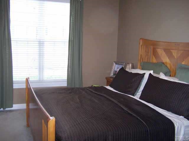 811 Rothshire Court, Unit 811 Raleigh, NC 27615 - Photo 6 of 7 a bed sitting in a bedroom next to a window