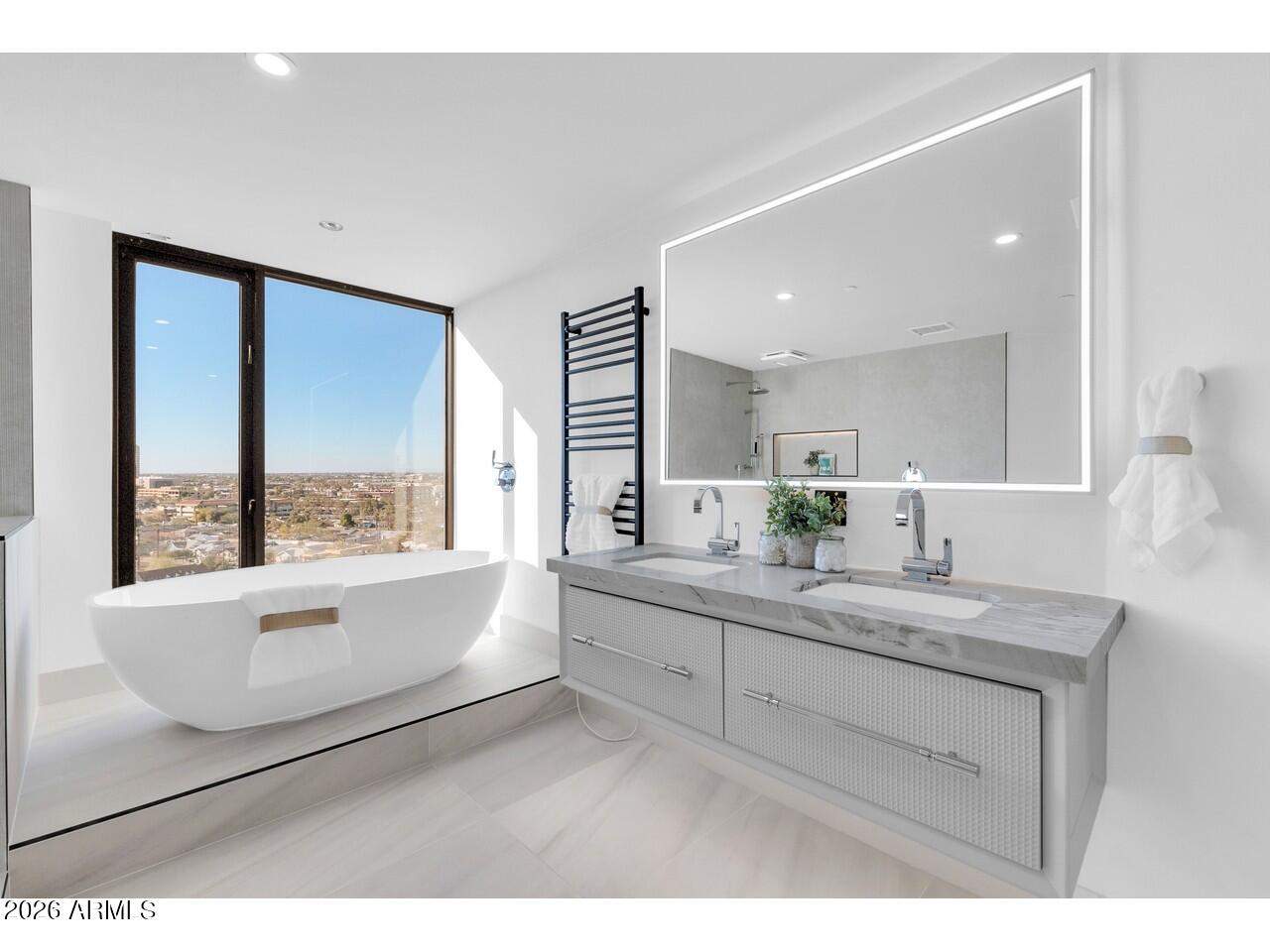 1040 East Osborn Road, Unit 1004 Phoenix, AZ 85014 - Photo 41 of 94 a bathroom with a sink a large mirror and a bathtub