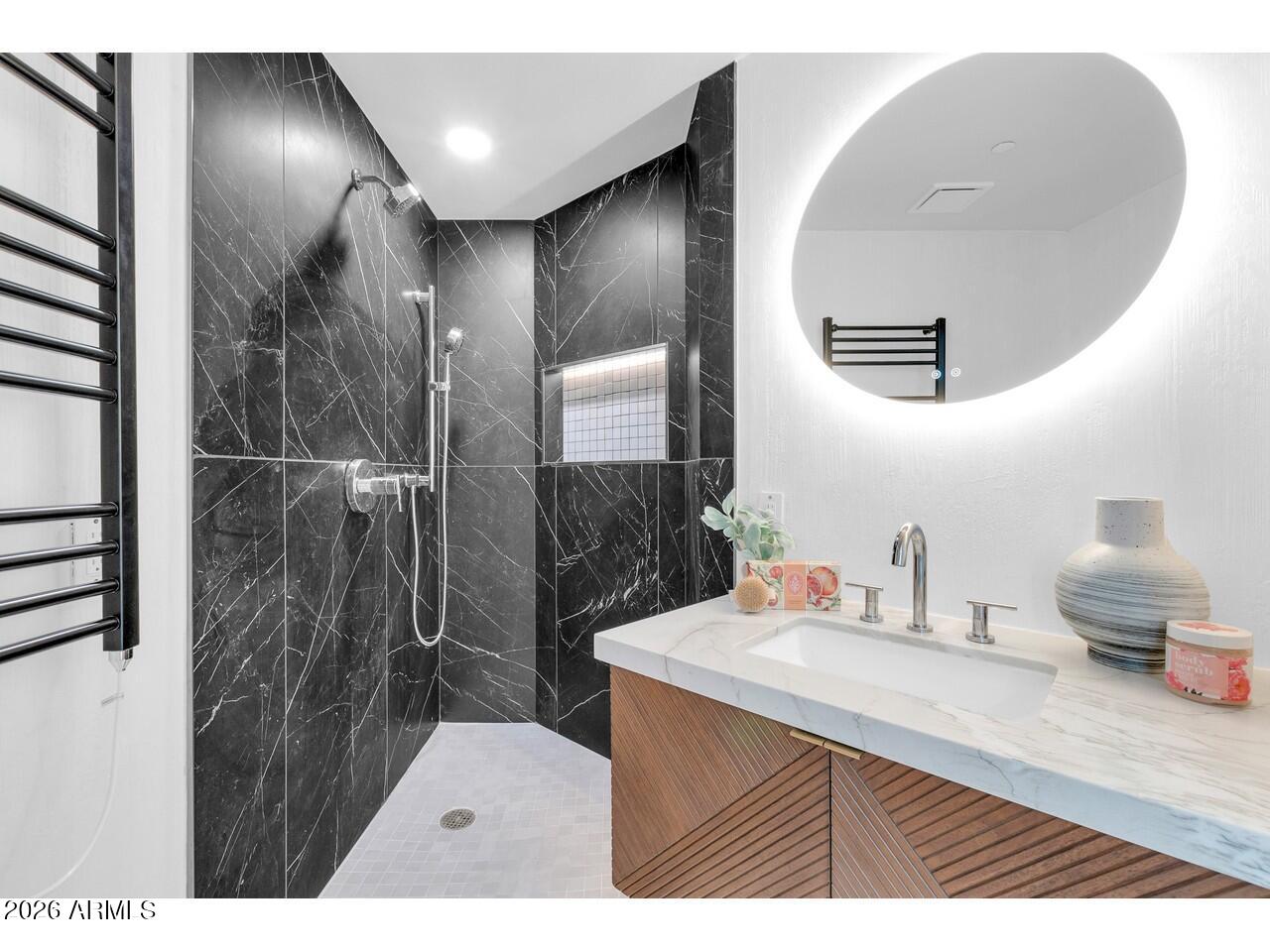 1040 East Osborn Road, Unit 1004 Phoenix, AZ 85014 - Photo 49 of 94 a bathroom with a sink a mirror and a shower