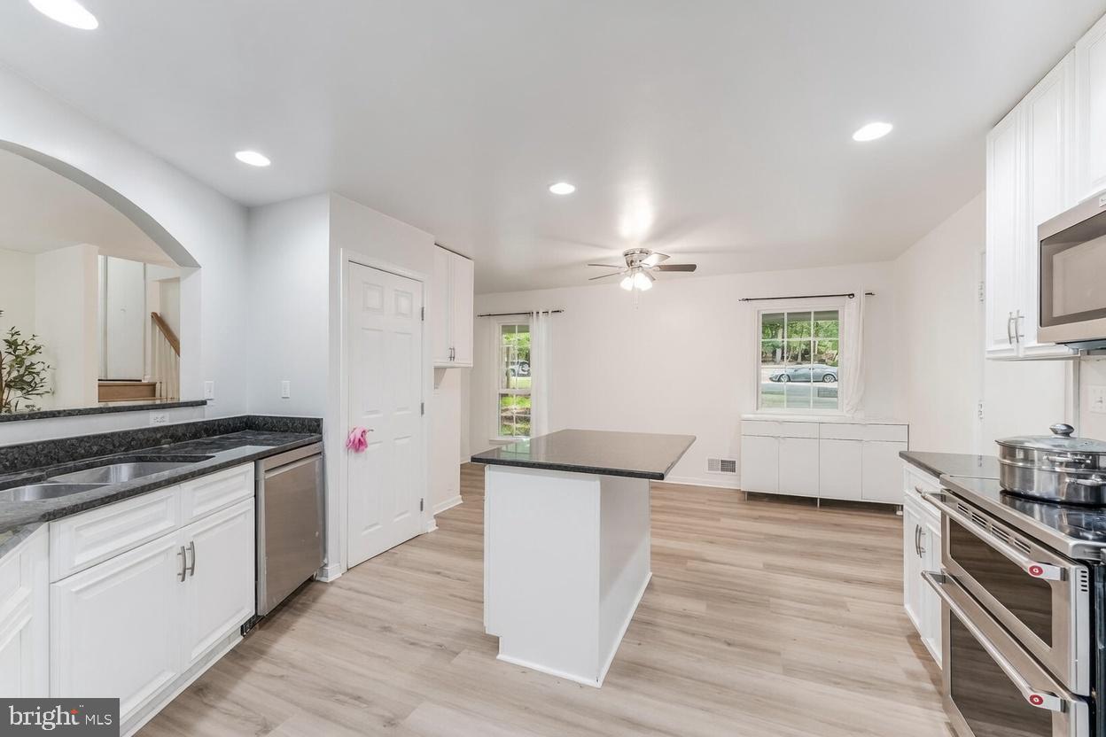 11621 Sourwood Lane Reston, VA 20191 - Photo 18 of 26 a kitchen with granite countertop a sink and a stove top oven
