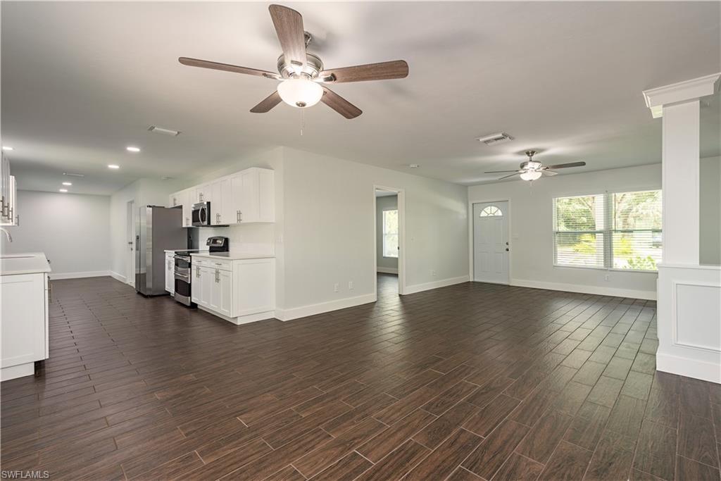 3831 31st Avenue Southwest Naples, FL 34117 - Photo 2 of 10 a view of a livingroom with furniture wooden floor a ceiling fan and windows