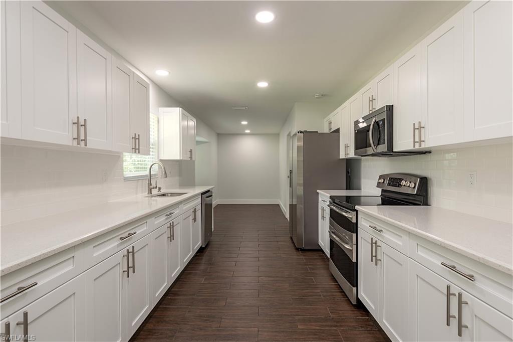 3831 31st Avenue Southwest Naples, FL 34117 - Photo 4 of 10 a kitchen with cabinets and stainless steel appliances