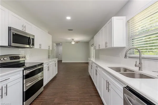 a kitchen with granite countertop a sink and steel appliances