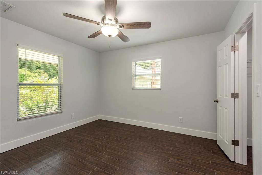 3831 31st Avenue Southwest Naples, FL 34117 - Photo 6 of 10 a view of an empty room with a window and wooden floor