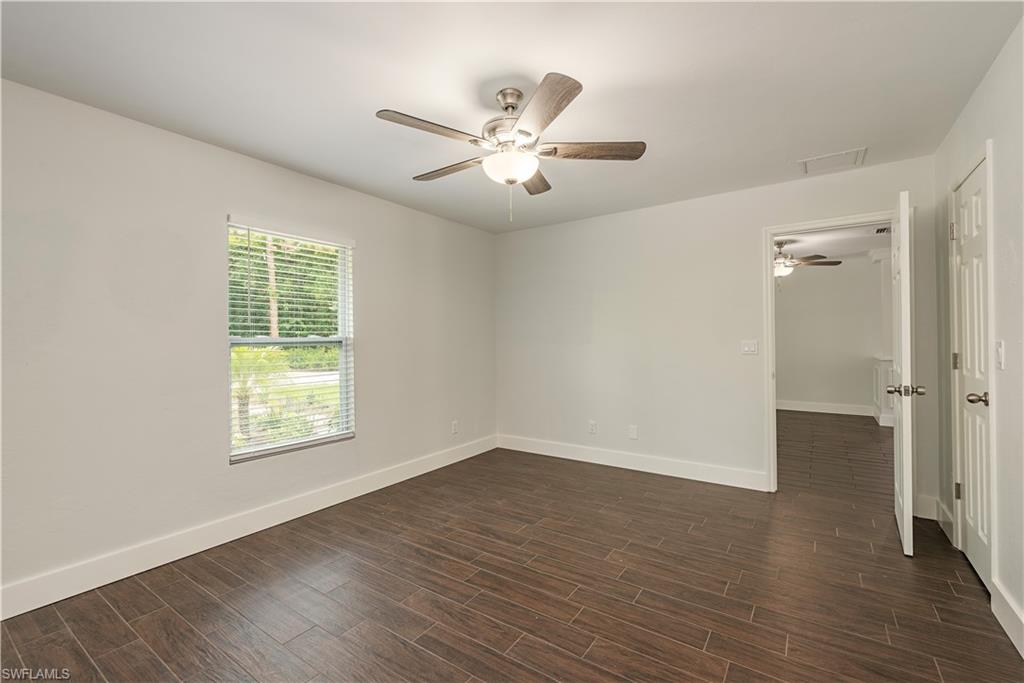 3831 31st Avenue Southwest Naples, FL 34117 - Photo 8 of 10 a view of an empty room with wooden floor and a window