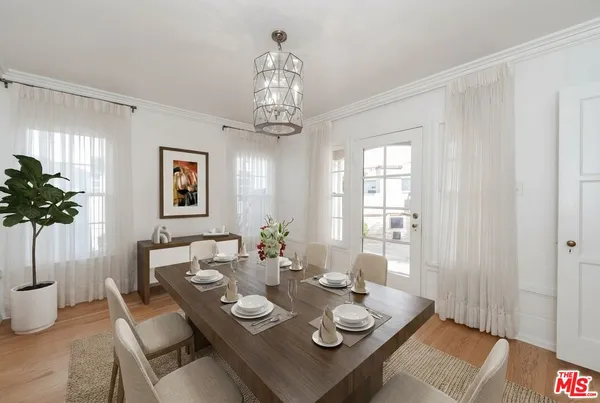 a view of a dining room with furniture wooden floor and chandelier