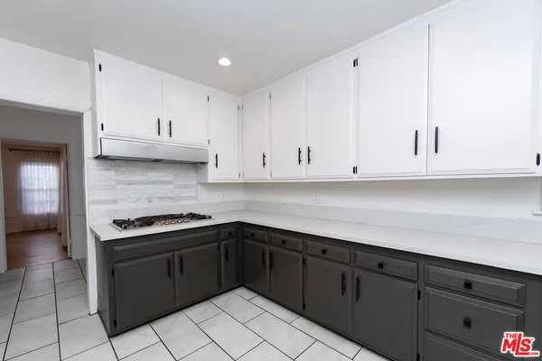 a kitchen with stainless steel appliances granite countertop a sink and dishwasher a stove top oven with white cabinets