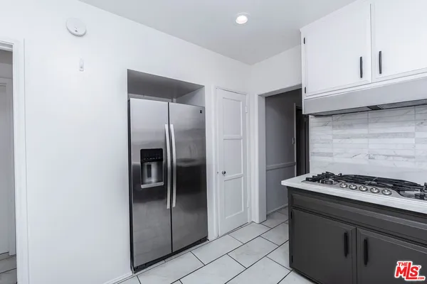 a kitchen with stainless steel appliances granite countertop a refrigerator and a stove top oven