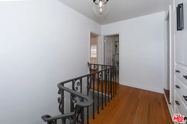 a view of a hallway with wooden floor and staircase