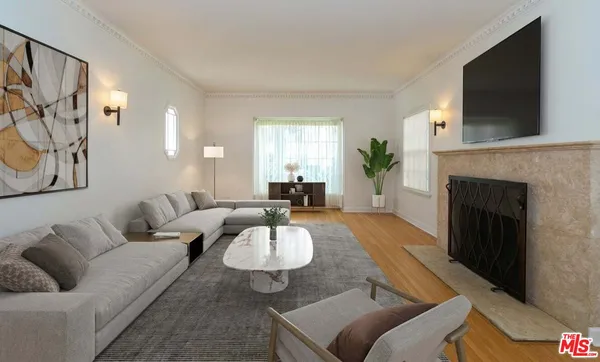 a living room with furniture a flat screen tv and a fireplace