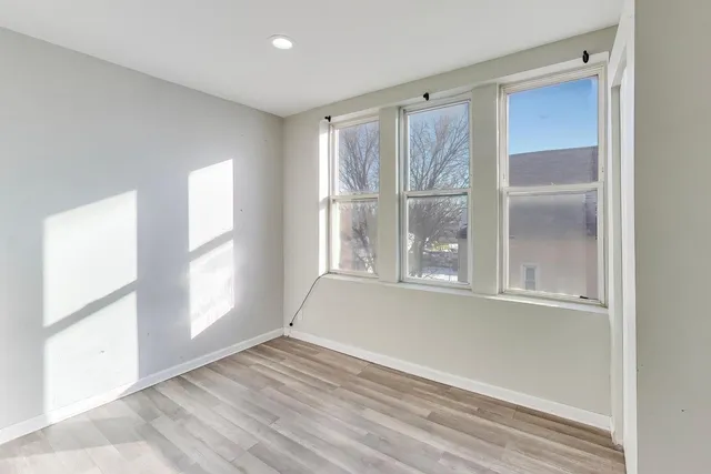 an empty room with wooden floor and a window