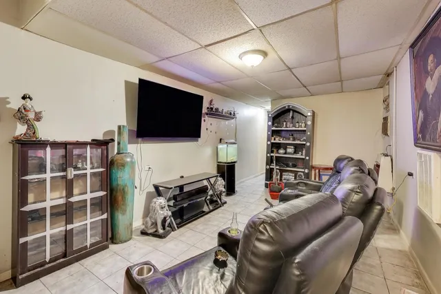 a living room with furniture a flat screen tv and gym equipment