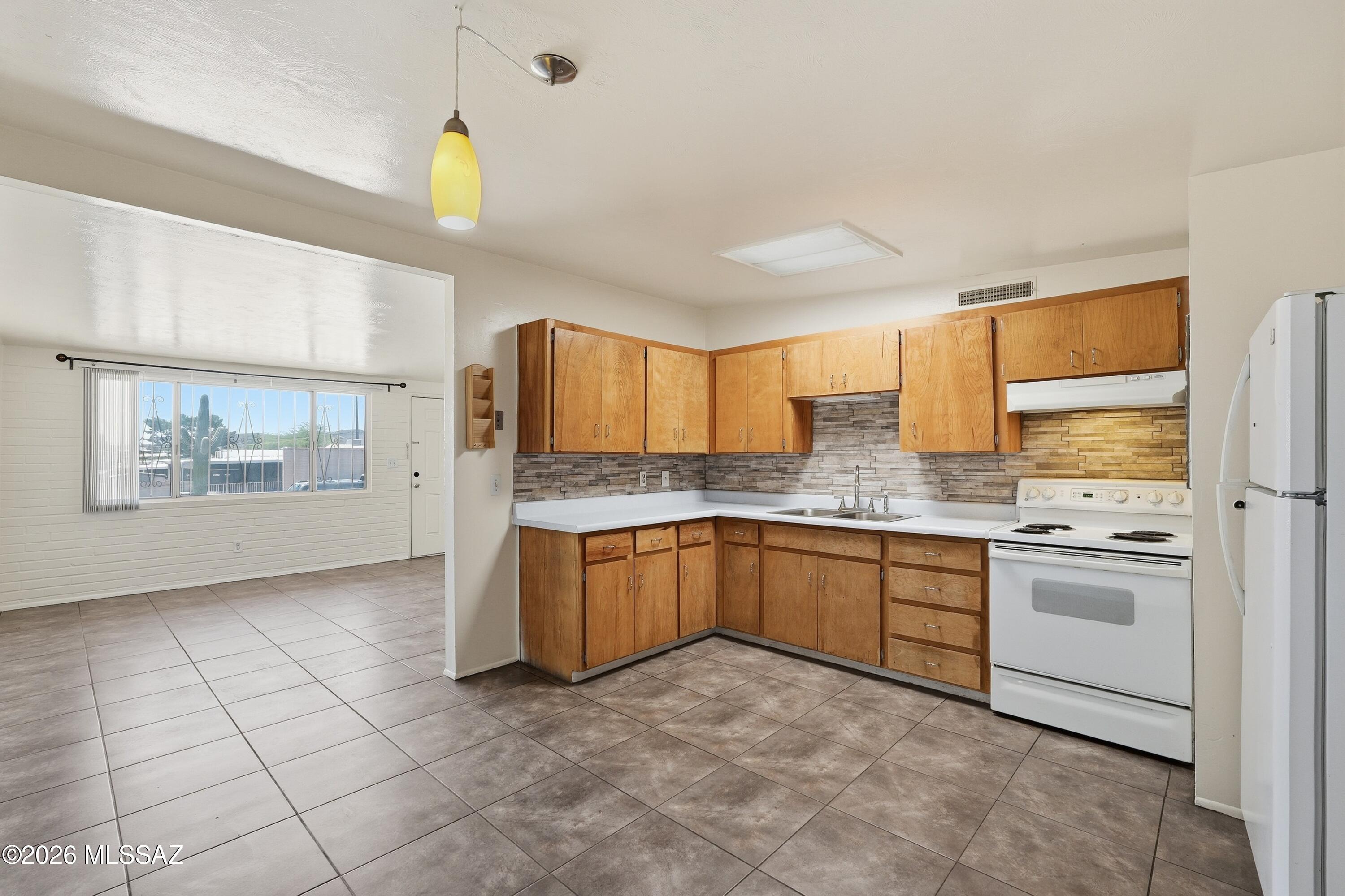 1808 West Caravelle Road Tucson, AZ 85713 - Photo 12 of 38 a kitchen with stainless steel appliances granite countertop a stove a sink and a refrigerator