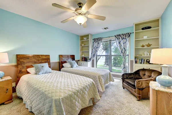 a spacious bedroom with two beds and a large window